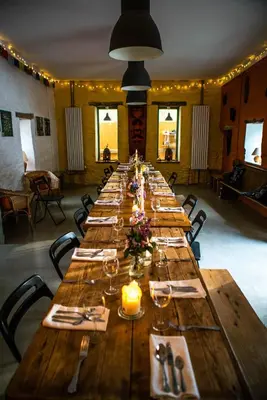 a large long wooden table in a room at Naturesbase Lodge in Cilcennin