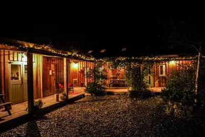 a house lit up at night with lights at Naturesbase Lodge in Cilcennin