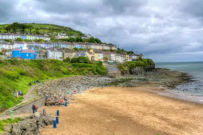 a group of people on a beach near the ocean at Dolphin View New Quay in New Quay