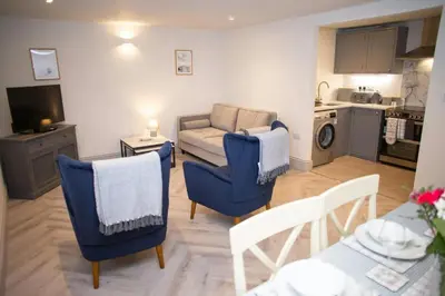 a living room with blue chairs and a couch at Dolphin View New Quay in New Quay