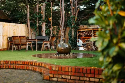 a fountain in a yard with a table and chairs at Cherry Tree House in Shrewsbury