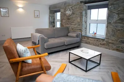 a living room with a couch and a table at Bay View New Quay in New Quay