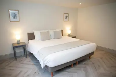 a bedroom with a large white bed with two lamps at Bay View New Quay in New Quay