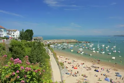 a group of people on a beach with boats in the water at Bay View New Quay in New Quay