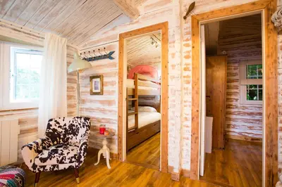 a bedroom in a log cabin with a chair and a bunk bed at Wunder Lodge - Snowdonia Log Cabin in Trawsfynydd