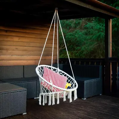 a basket swing on a porch with a chair at Wunder Lodge - Snowdonia Log Cabin in Trawsfynydd