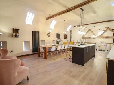 a large room with a kitchen and a dining room at Godre'r Gyrn, Plas Moelfre Hall Barns in Oswestry