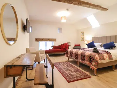 a bedroom with a bed and a living room at Godre'r Gyrn, Plas Moelfre Hall Barns in Oswestry