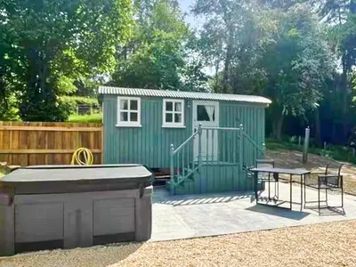 a small green shed with a table and a picnic table at Bryn Gwyn - Ukc7801 in Shrewsbury