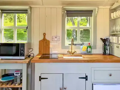 a kitchen with a counter with a sink and two windows at Bryn Gwyn - Ukc7801 in Shrewsbury