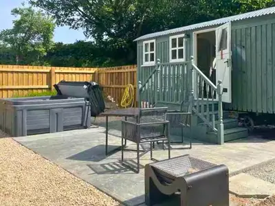 a backyard with a green shed and a table and chairs at Bryn Gwyn - Ukc7801 in Shrewsbury