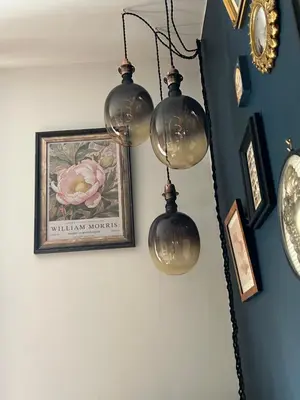 a group of lights hanging on a wall with a picture at The Cwtch in Ludlow