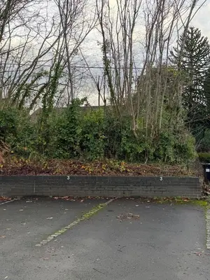 a brick retaining wall next to a parking lot at Woodland View House in Norton Canon