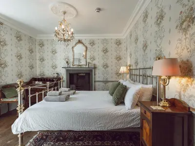 a bedroom with a bed and a chandelier at Belmont House in Hay-on-Wye