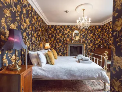 a bedroom with a bed and a chandelier at Belmont House in Hay-on-Wye