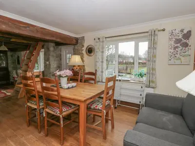 a dining room with a wooden table and chairs at Glanyrafon Smithy in Llandysul