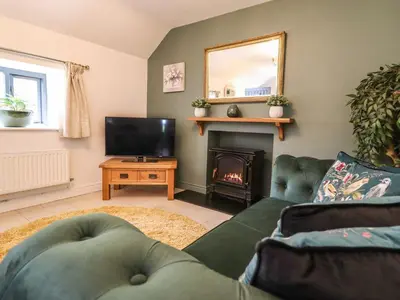 a living room with a couch and a fire place at The Talkhouse Cottage in Caersws