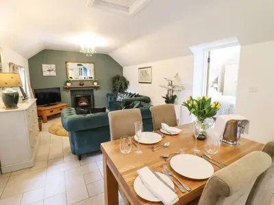 a dining room and living room with a table at The Talkhouse Cottage in Caersws