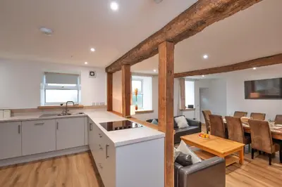 a kitchen and living room with a table and chairs at Finest Retreats - Brecon House in Builth Wells