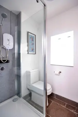 a bathroom with a toilet and a glass shower at Finest Retreats - Brecon House in Builth Wells