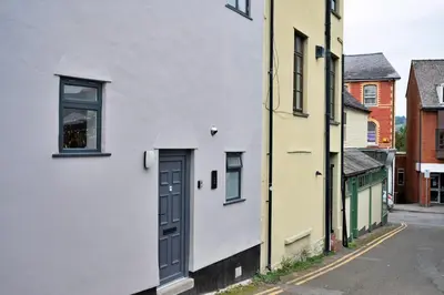 a white building with a door on a street at Finest Retreats - Brecon House in Builth Wells