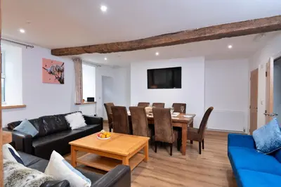 a living room with a table and a dining room at Finest Retreats - Brecon House in Builth Wells