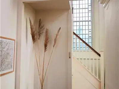 a hallway with a staircase with a window and a plant at Capel Pennal in Pennal