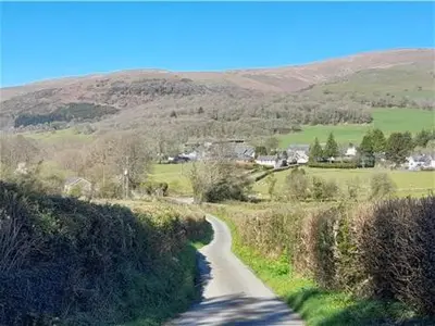 a winding road in the middle of a field at Capel Pennal in Pennal