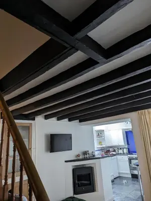 a living room with a ceiling with black beams at Neifion in Aberdyfi