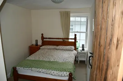 a bedroom with a bed with a green and white comforter at Neifion in Aberdyfi