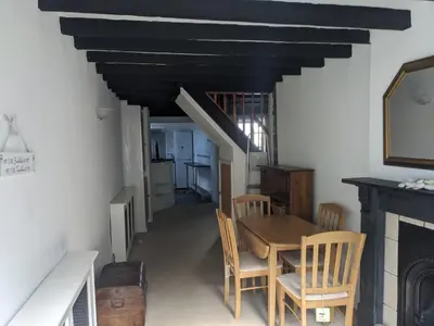 a dining room with a table and chairs and a fireplace at Neifion in Aberdyfi