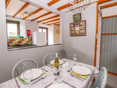 a dining room with a white table and chairs at Old Farmhouse Cottage in New Quay