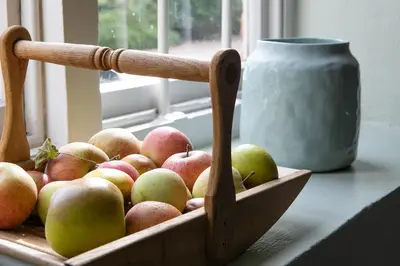 a wooden basket of apples sitting on a window sill at Wyvern House in Alberbury
