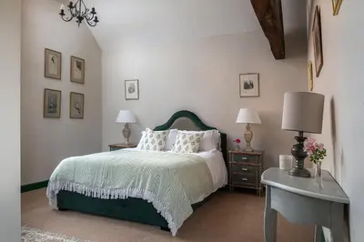 a bedroom with a bed and two tables with lamps at Wyvern House in Alberbury