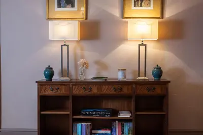 two lamps on top of a book shelf with books at Wyvern House in Alberbury