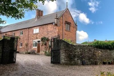 an old brick building with a gate in front of it at Wyvern House in Alberbury