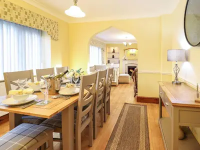 a dining room with a wooden table and chairs at Llwyn Derw in Talybont
