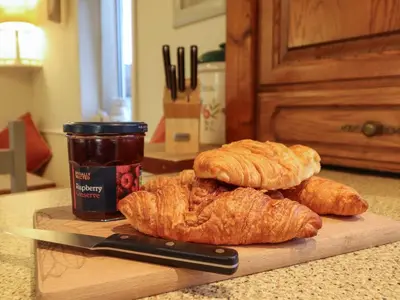 a cutting board with croissants and a knife on a counter at Llwyn Derw in Talybont