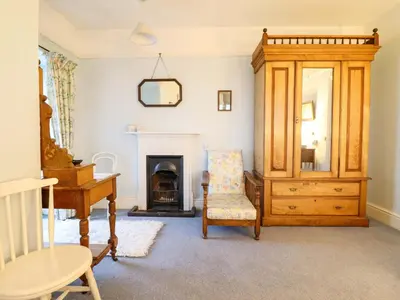 a living room with a piano and a chair at Murmur Y Don in Harlech