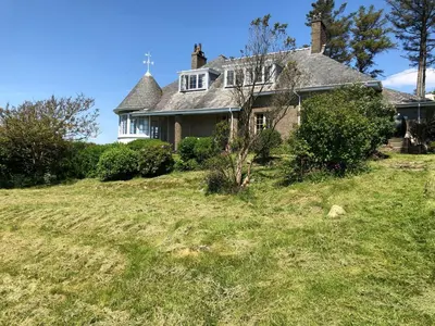 a house on top of a grassy hill at Murmur Y Don in Harlech