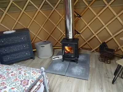 a wood stove in a room with a wall at Willey Lane Farm in Lingen
