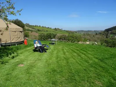 a woman sitting in a chair in a field next to a tent at Willey Lane Farm in Lingen