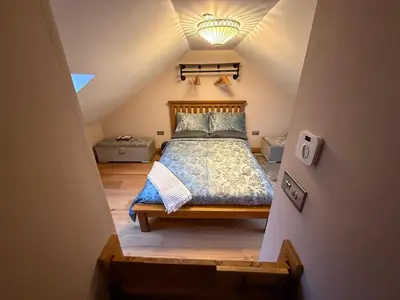 a bedroom with a bed in a attic at Nantsidyll Farm Spa & Holiday Lodges in Mydroilin