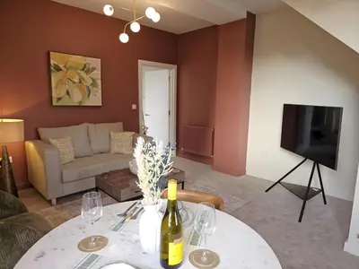 a living room with a table with a bottle of wine at Elegant interior-designed ground floor apartment - Pass the Keys in Shrewsbury