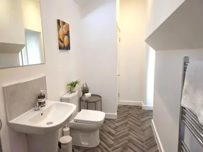 a white bathroom with a toilet and a sink at Elegant interior-designed ground floor apartment - Pass the Keys in Shrewsbury