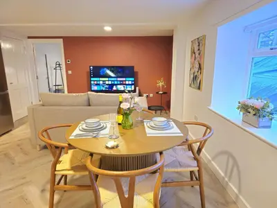 a living room with a table and chairs and a couch at Stylish and spacious lower ground floor apartment -Pass the Keys in Shrewsbury
