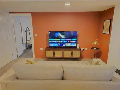 a living room with a couch and a flat screen tv at Stylish and spacious lower ground floor apartment -Pass the Keys in Shrewsbury