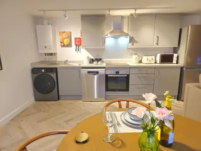 a kitchen with a wooden table and a dining room at Stylish and spacious lower ground floor apartment -Pass the Keys in Shrewsbury
