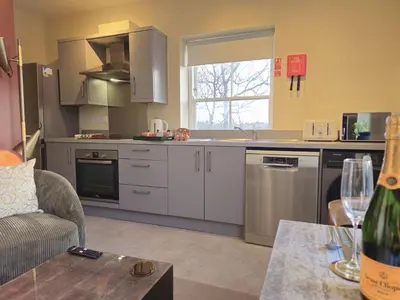 a kitchen with stainless steel appliances and a table at Contemporary first-floor apartment close to town - Pass the Keys in Shrewsbury
