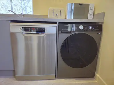 a kitchen with a washing machine and a counter at Contemporary first-floor apartment close to town - Pass the Keys in Shrewsbury